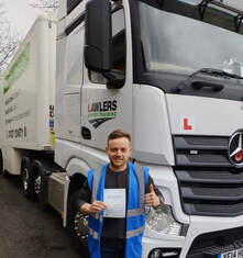 Newly qualified driver holding pass certificate by HGV class 1 category c+e licence training lorry in Bradford