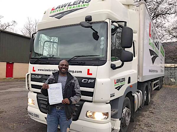 Newly qualified class 1 artic with trailer category c + e  hgv driver holding pass certificate in front of HGV truck