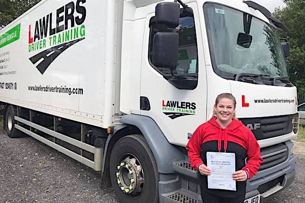 Lady holding pass certificate in front of HGV Class 2 Category C Training Vehicle
